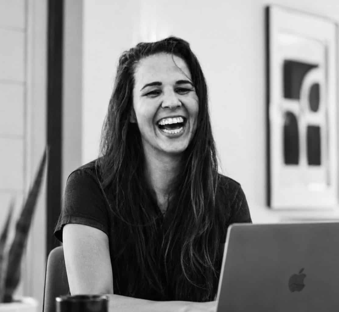 Manon Vernay, founder and web designer at Creative Baguette, laughing at her laptop